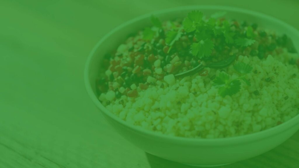 A colorful bowl of cooked quinoa with white, red, and black seeds, garnished with fresh herbs, on a rustic wooden table, natural lighting, realistic.