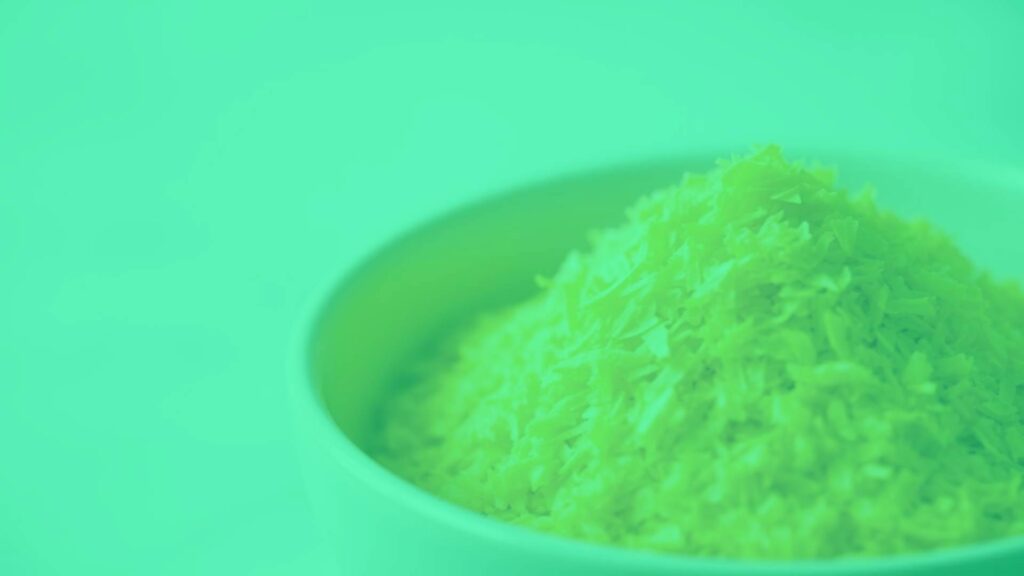 A bowl of golden yellow nutritional yeast flakes, macro shot, soft lighting, clear focus on texture, nutty and savory feel, minimalist background, food photography style.