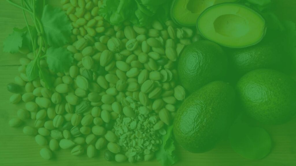 A vibrant assortment of vitamin E-rich foods for vegetarians, including nuts, seeds, leafy greens, and avocados, arranged on a wooden table, natural lighting, realistic.