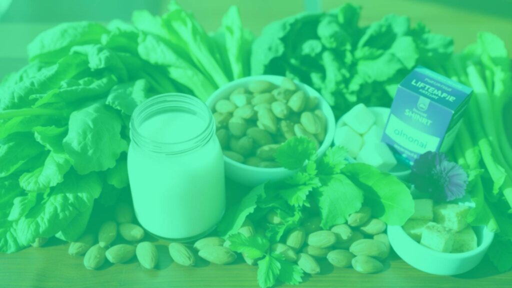 A vibrant assortment of vegetarian calcium-rich foods like leafy greens, almonds, tofu, and fortified plant milk, neatly arranged on a wooden table, natural sunlight, bright and healthy vibe.