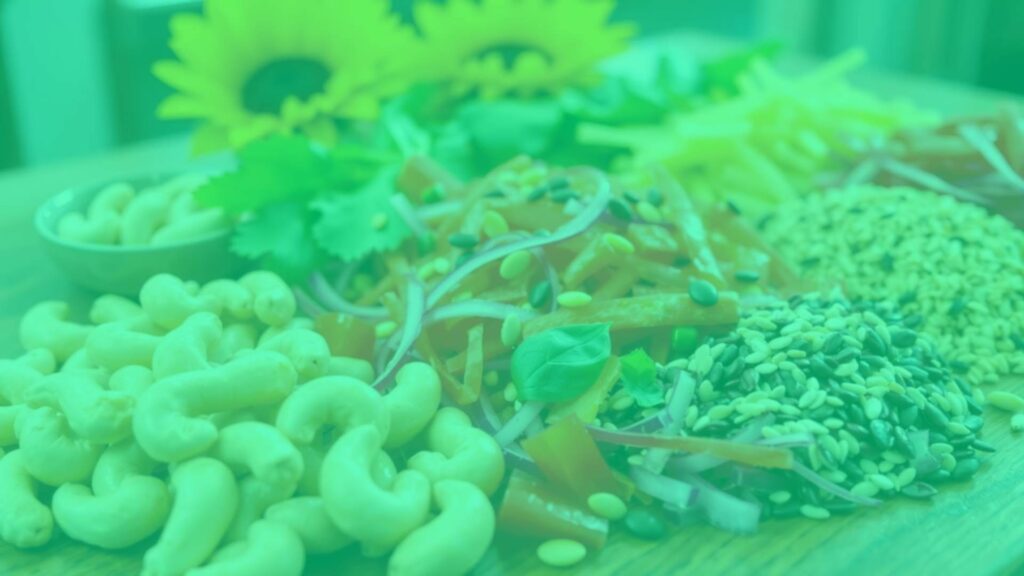 A colorful assortment of vegetarian copper-rich foods like cashews, sunflower seeds, and sesame seeds arranged artistically on a wooden table, natural lighting, vibrant and healthy.